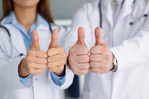 Close-up of doctors hands show ok or confirm sign with thumb up. High level therapy, great heal participation, healthy lifestyle, satisfied patient concept