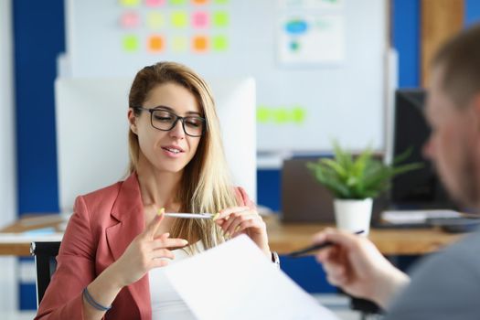 Portrait of workers meet in office to talk on important issue for company. Woman in suit hold pen and explain idea to colleague. Business, creative concept