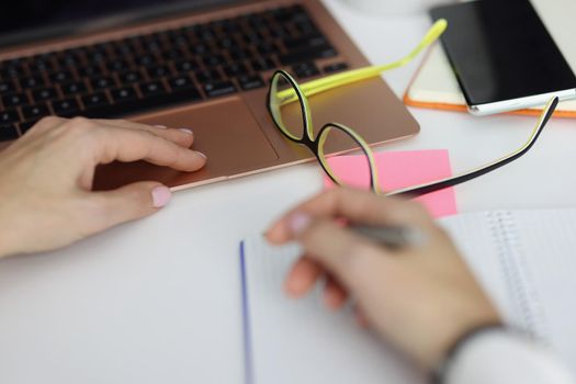 Close-up of male hold pen and make notes in notebook, plan day, working at laptop. Man office clerk, employee at work. Journal, creativity, writer concept