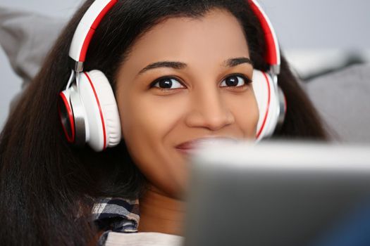 Portrait of latino american young woman wear headset and watch movie or take online class. Smiling female on remote education from home. Technology concept