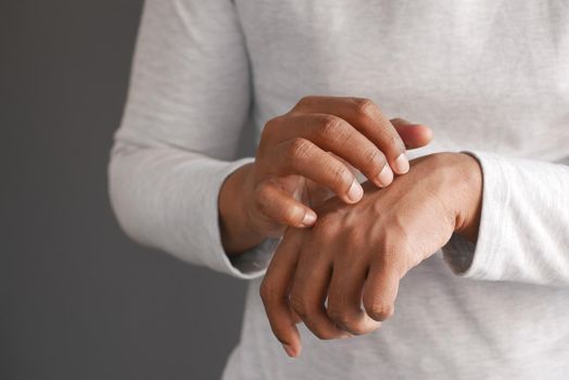 man suffering from itching skin, close up
