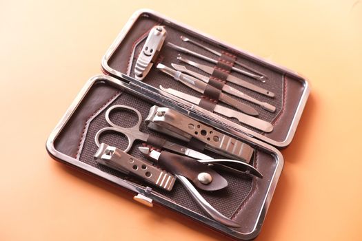 nail cutters for a manicure on orange background .