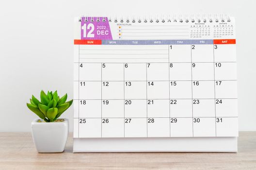 The December 2022 desk calendar on wooden table.