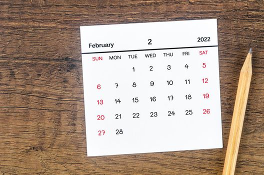 The February 2022 calendar on wooden background.