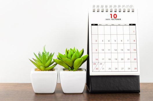 The October 2022 desk calendar on wooden table.