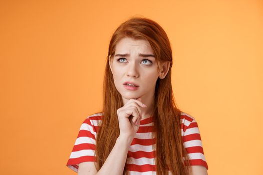 Perplexed redhead woman trying make calculations mind, frowning focused, look up puzzled thoughtful, touch chin, thinking, pondering important decision, make choice, solve problem.