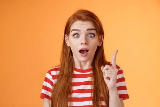 Got idea. Excited redhead woman sharing interesting plan, raise index finger eureka gesture, open mouth say thought, remember important thing, stare camera stunned, finally understand.