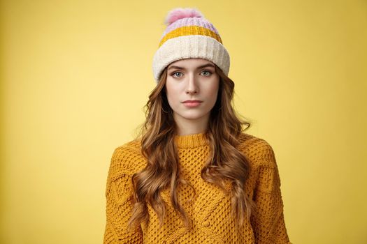 Close-up worried upset attractive young 20s woman look serious nervous sympathizing you listening terrible upsetting story standing yellow background looking camera, wearing hat sweater.