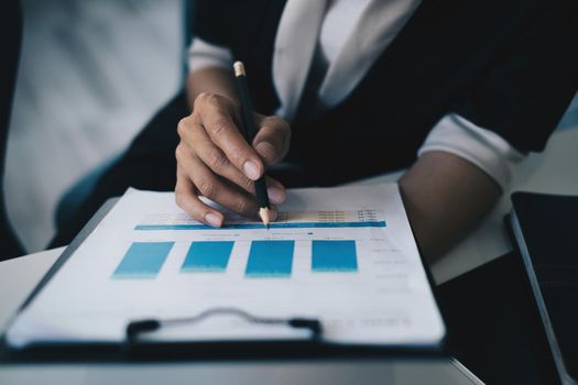 Business woman analyst financial advisor preparing statistical report searching documents on work desk, browsing information