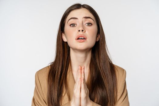 Close up portrait of corporate woman begging, pleading and saying please with desperate face expression, white background.