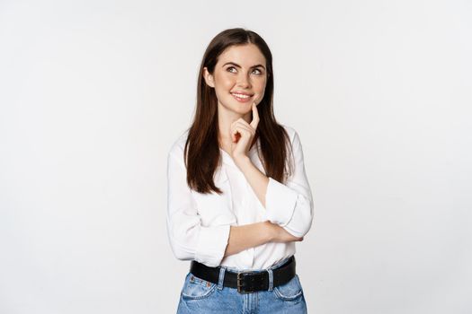 Portrait of female entrepreneur thinking, making choice, standing thoughtful, white studio background.