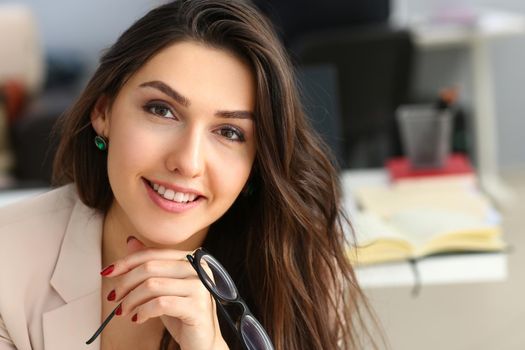 Smiling confident businesswoman at workplace looks up. Workplace worker dress code and job offer customer visit concept