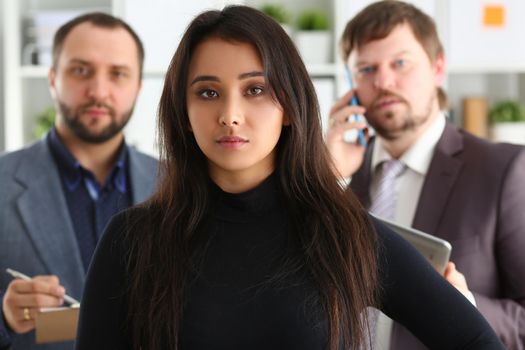 Portrait of young successful business woman and two businessmen in office. Successful collaboration concept