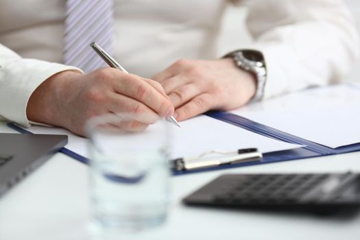 Man hand holds pen and fills out schedule of working day. Financial investment expert consultation concept