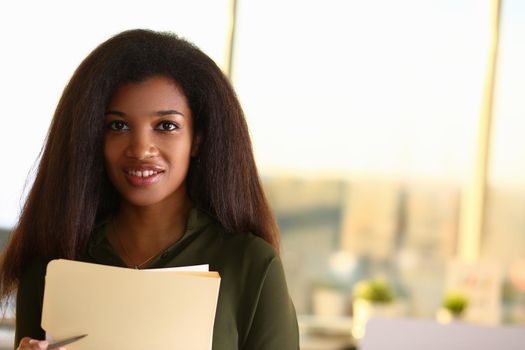 Beautiful smiling businesswoman portrait holding business documents. Business consultant concept