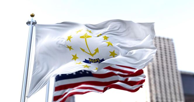 the flag of the US state of Rhode Island waving in the wind with the American flag blurred in the background. Rhode Island was admitted to the Union on May 29, 1790 as 13th state