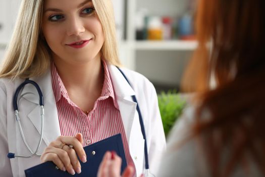 Female doctor explains diagnosis to patient. Medical consultation concept