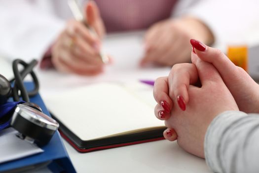 Hands of woman patient for medical report written by doctor about health condition. Medical service concept