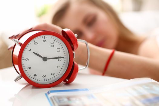 Young woman wakes up from morning alarm clock. Early awakening and fatigue concept