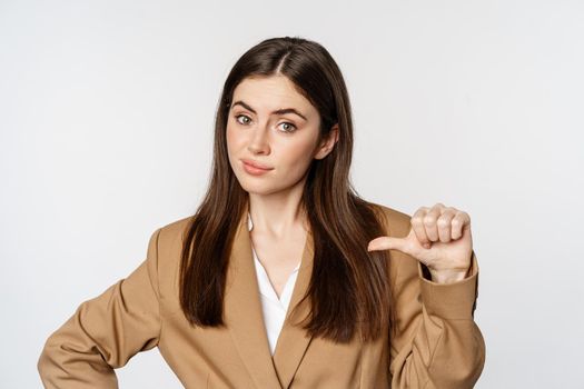 Portrait of confident saleswoman, businesswoman pointing at herself and looking like real professional, white background.