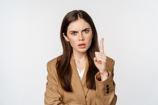 Angry corporate woman, boss shaking finger disapproval, scolding someone, prohibit something, standing over white background.