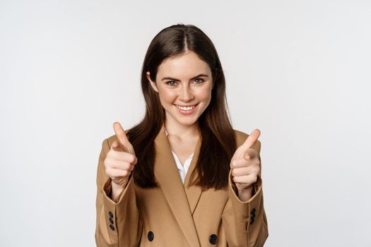 Enthusiastic businesswoman, corporate woman showing thumbs up and smiling, complimenting, recommending company, standing over white background.