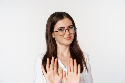 Close up portrait of corporate woman, adult student rejecting smth, raising hands in block, no gesture, refusing, standing over white background.
