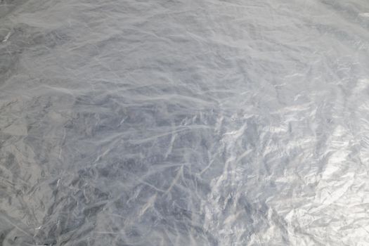 full frame background of flat crumpled semi-transparent polyethylene film.