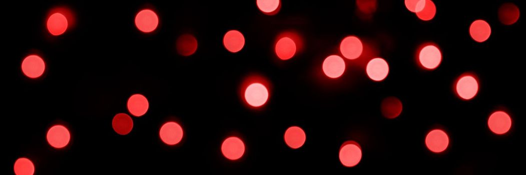 Banner of Defocused bokeh lights on black background, an abstract naturally blurred backdrop for Valentine Day or birthday party. Festive light texture. Pink and red garland in blur. Overlay effect