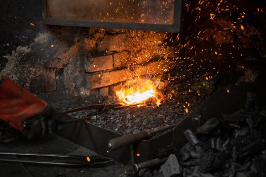 blacksmith warming blank metal on coal fire. High quality photo