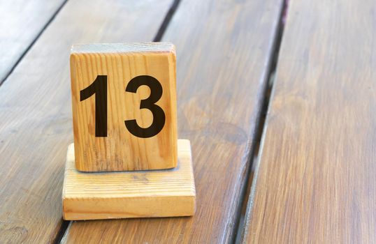 Wooden priority number 13 on a plank tab.
