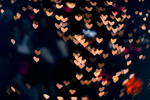 orange bokeh and blur heart shape love valentine colorful night light at shopping mall