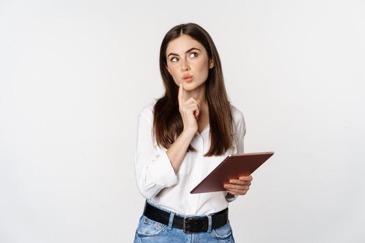 Image of woman standing with digital tablet and thinking, choosing, order online, shopping in app, standing over white background.