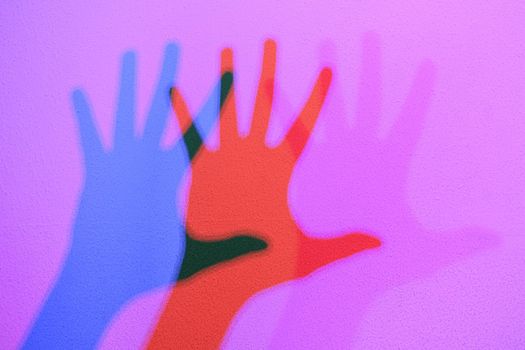 Colored shadows of a hand dancing to the music. Interactive exposition in science museum.