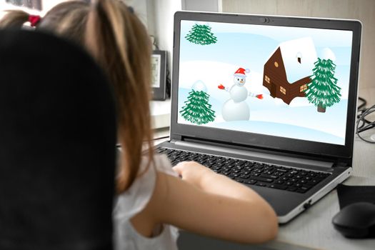 a child watches a cartoon about winter and a snowman on a laptop