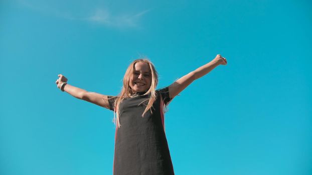 Happy jumping girl on a background of blue sky