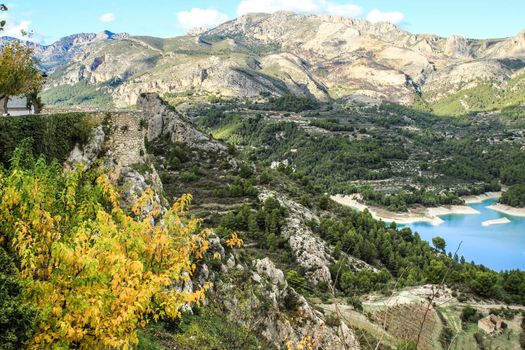 Beautiful view of Guadalest village surrounded by vegetation, mountains and the walls of the Castle