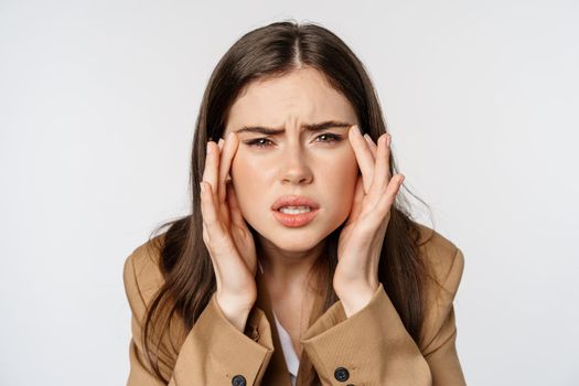 Close up portrait of business woman squinting and looking without glasses, cant see, bad sight without eyewear, standing over white background.