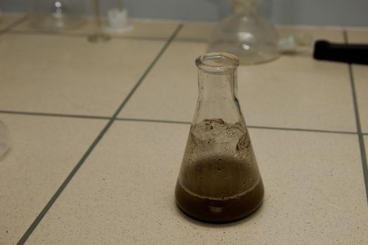 Glassware with soil extract. Laboratory research. Close-up.