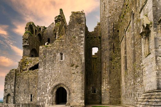 Rock of Cashel ruins at sunset with reddish clouds. One of the most beautiful and impressive medieval ruins in Ireland.