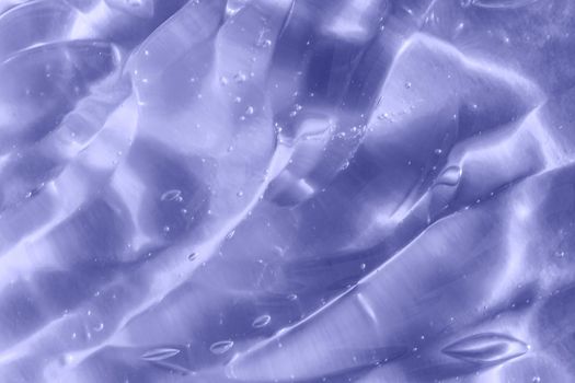 Color of the year 2022. Texture of transparent light violet blue gel with air bubbles and waves on soft background. Concept of skin moisturizing and prevention of covid. Liquid beauty product closeup