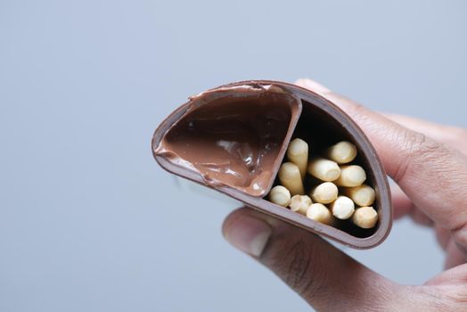 holding Chocolate Hazelnut cream in a container top view .