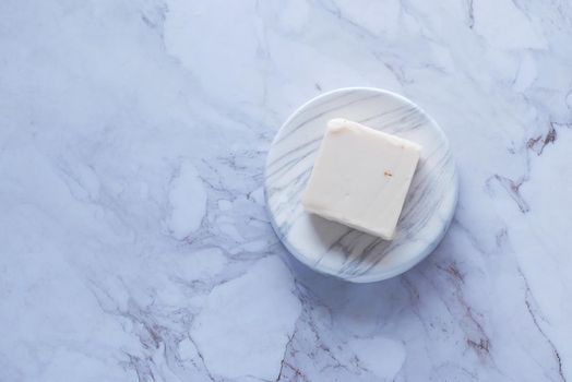 Homemade natural soap bar on black background .