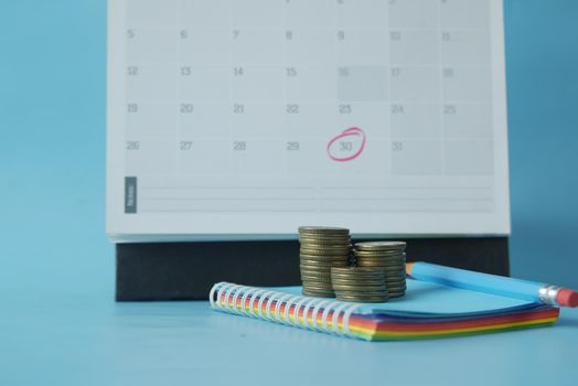 stack of coins and calendar on table .