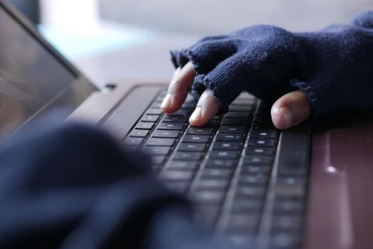 hacker hand stealing data from laptop top down.