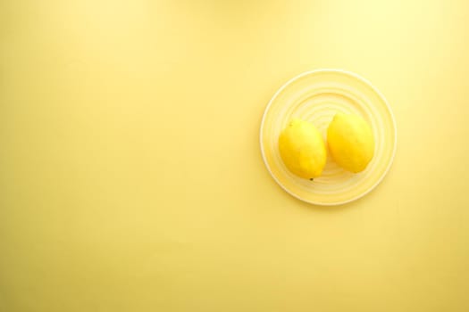 Yellow Lemon on a plate top view .