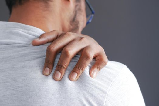 man suffering from neck or shoulder pain at home