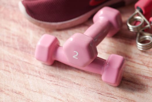 pink color dumbbell, exercise mat and water bottle on white background .