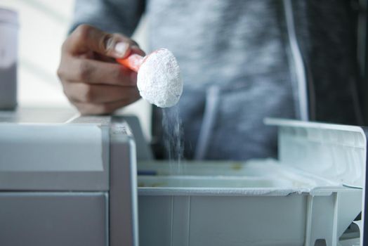 pouring Washing powder in plastic tray .