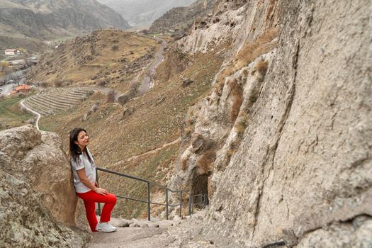 Beautiful girl tourist walks in the historical cave city in the rock.